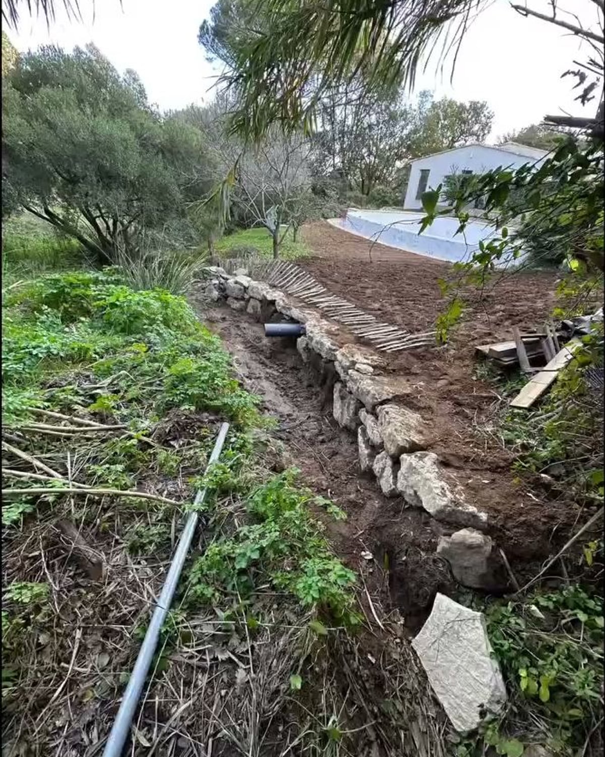 Tranchée drainante le long d'un mur en pierre, réseau pluvial à Ramatuelle